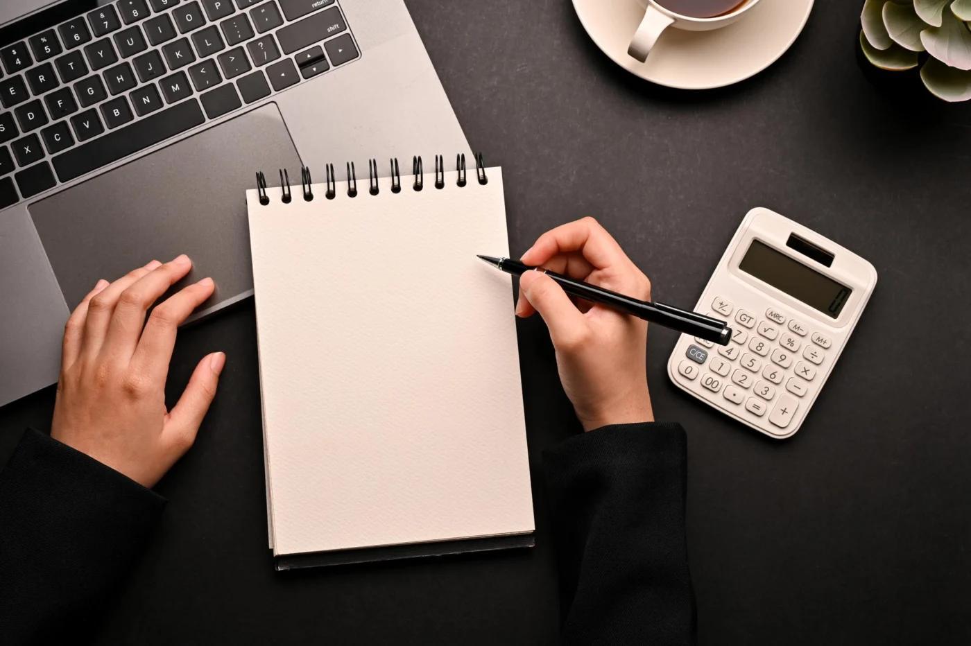 A laptop showing a profit-and-tax spreadsheet on a desk