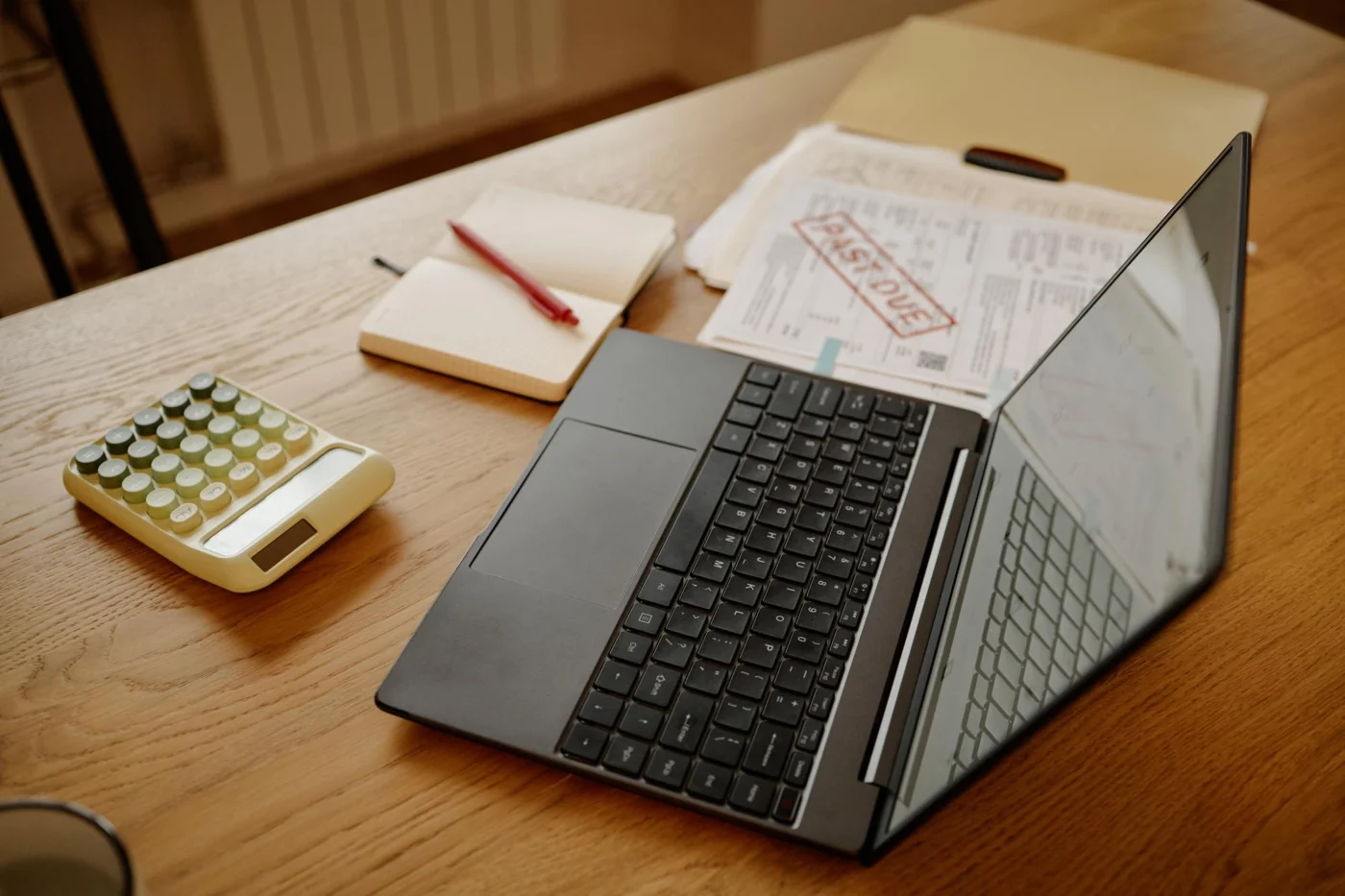 A budget notebook and laptop on a desk, planning company running costs