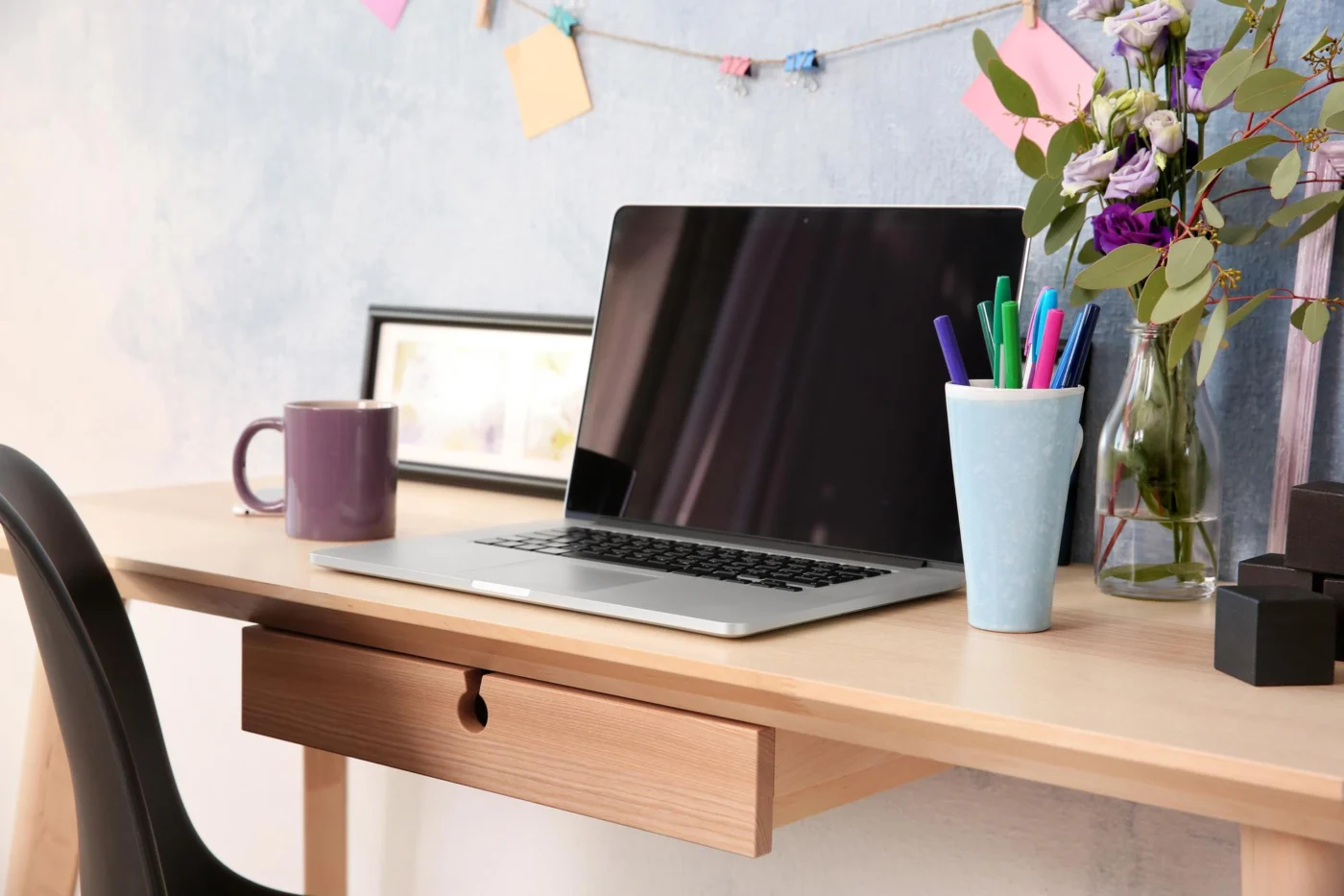 A tidy home-office workspace with a laptop and notebook