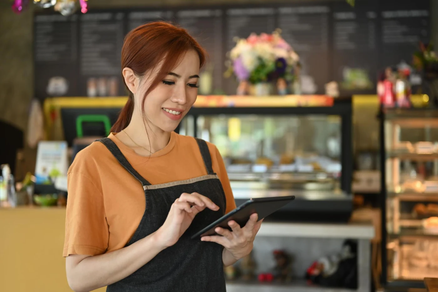 A director at a café working on a laptop with a bank card to hand