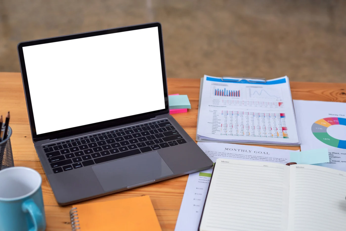 A director checking company figures on a laptop spreadsheet at a desk