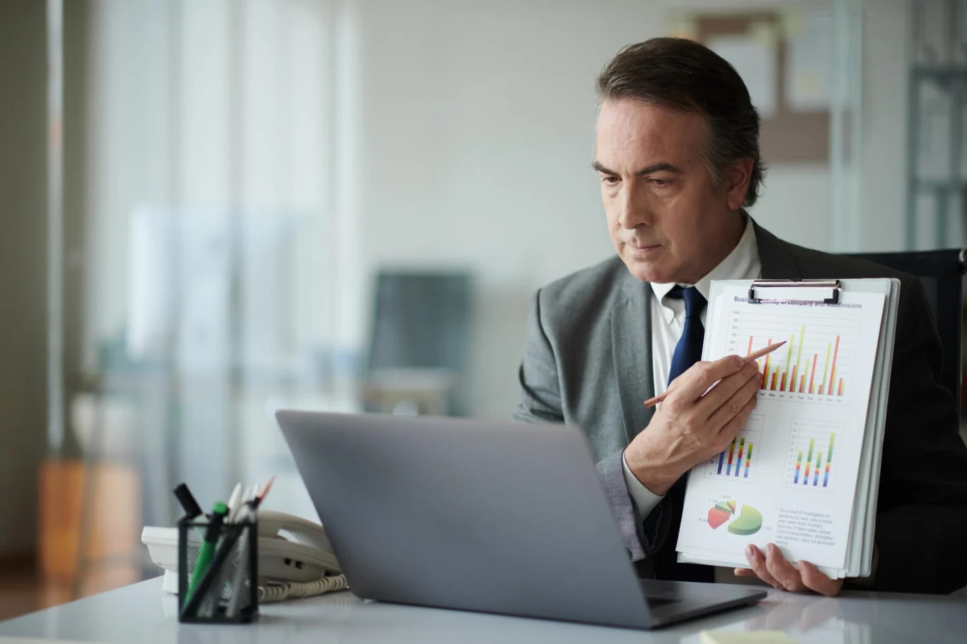 A director reviewing car finance figures on a laptop