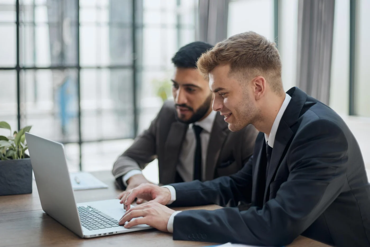 Two business partners reviewing company plans at a laptop