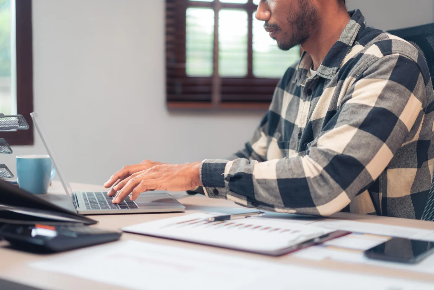 A laptop showing a Companies House filing alongside company paperwork