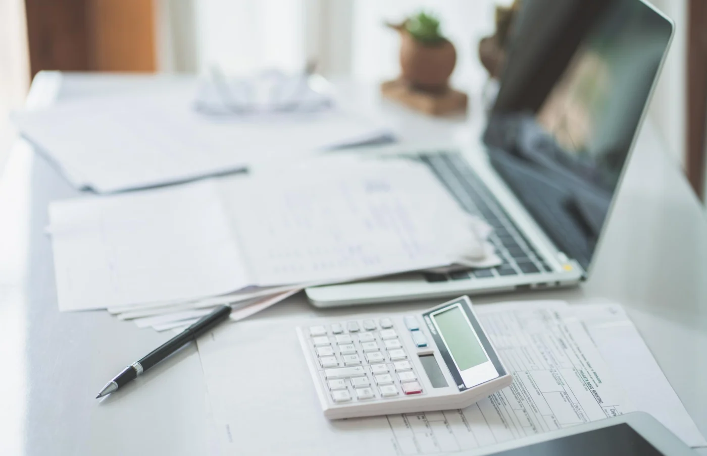 A laptop showing management accounts and a retained profit figure beside a notebook