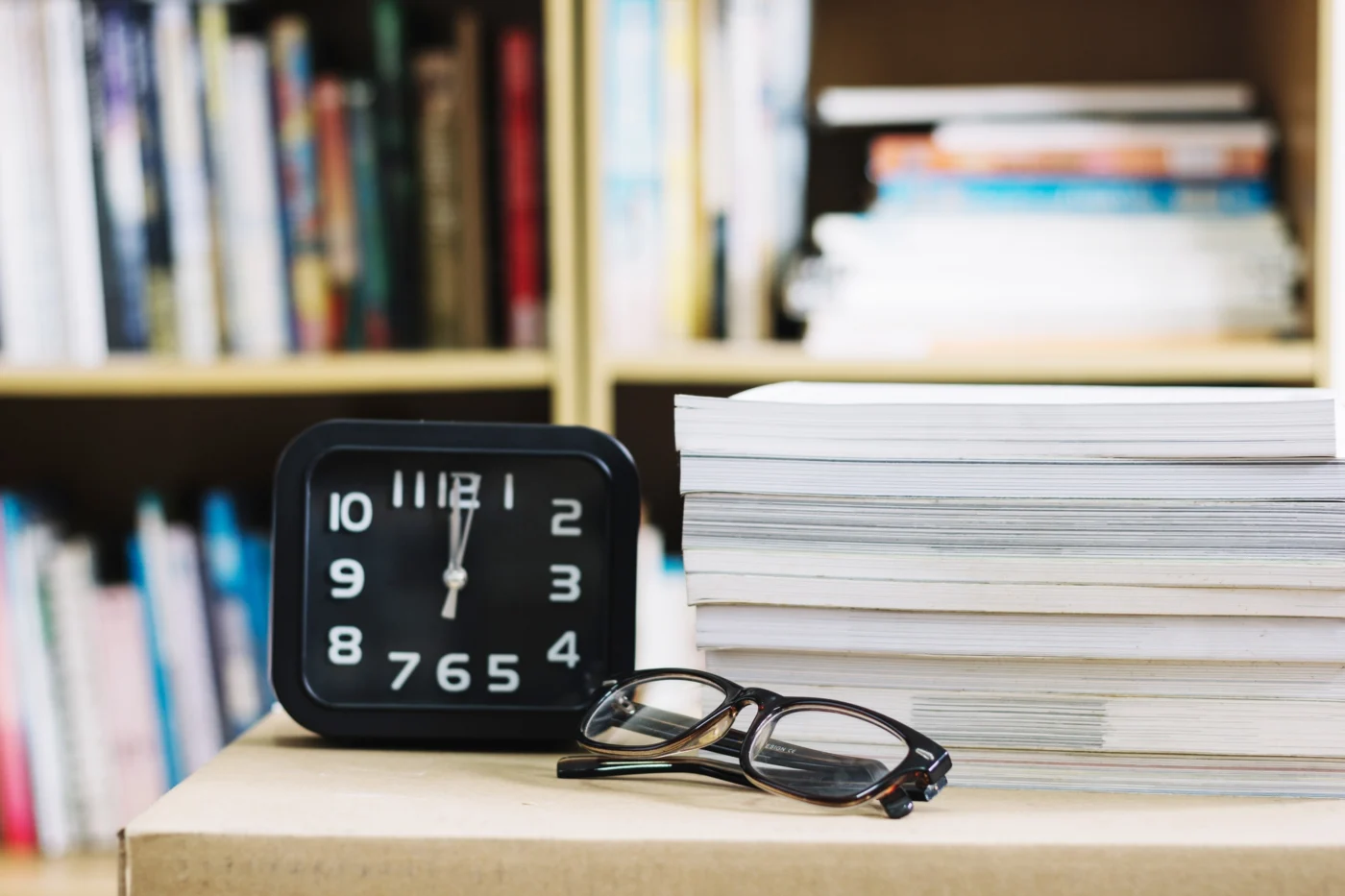 Alarm clock and reading glasses, representing a time-sensitive tax deadline