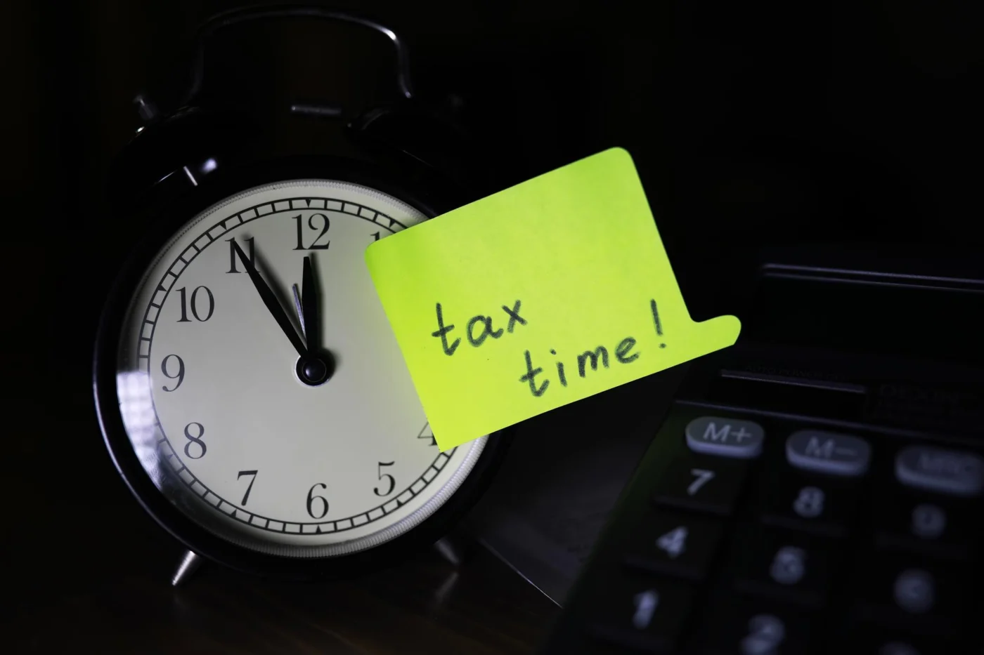 Vintage alarm clock and calculator, symbolising a tax filing deadline